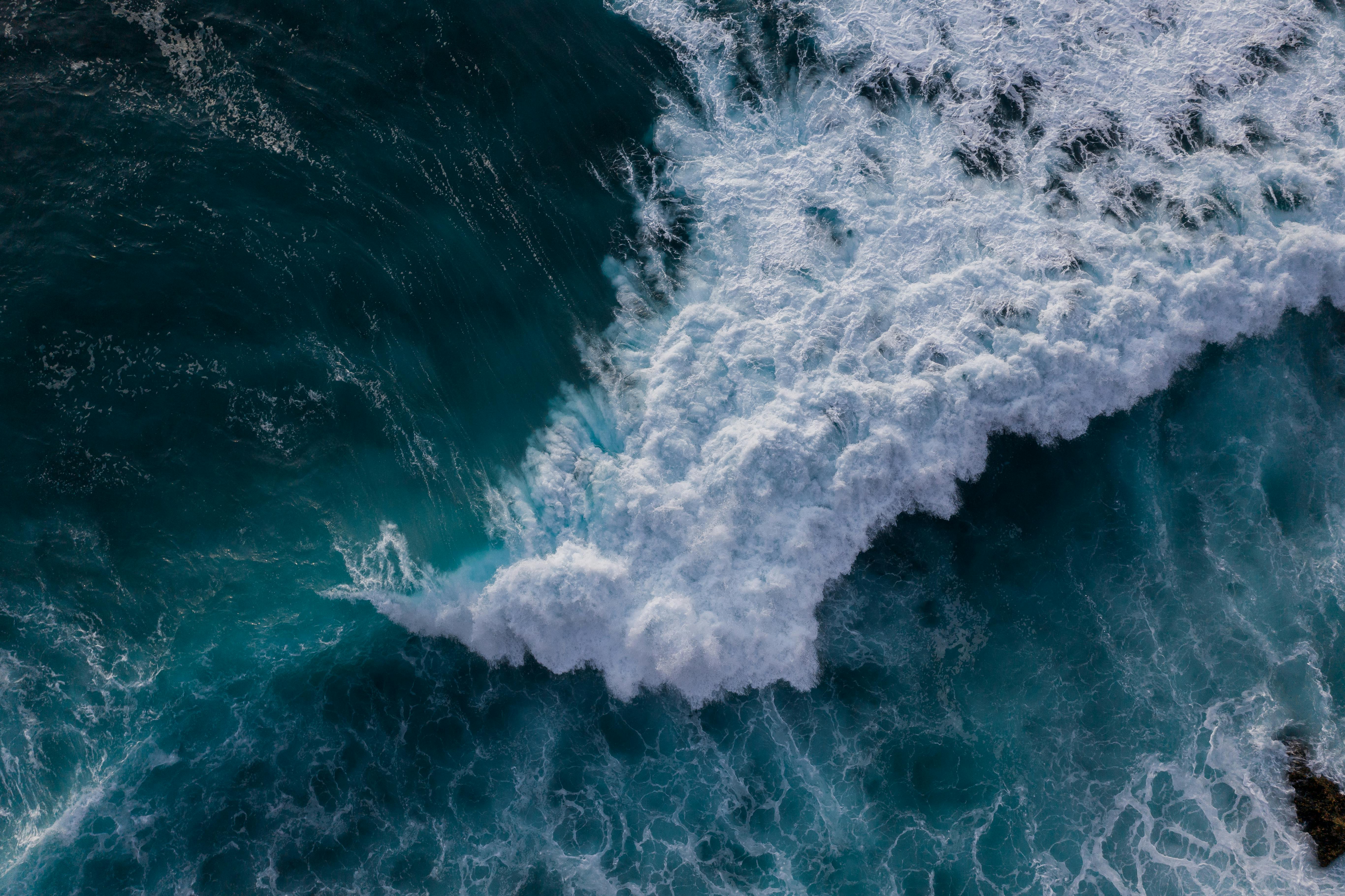 Aerial view of powerful ocean waves crashing against the rocks, capturing the essence of nature's strength.