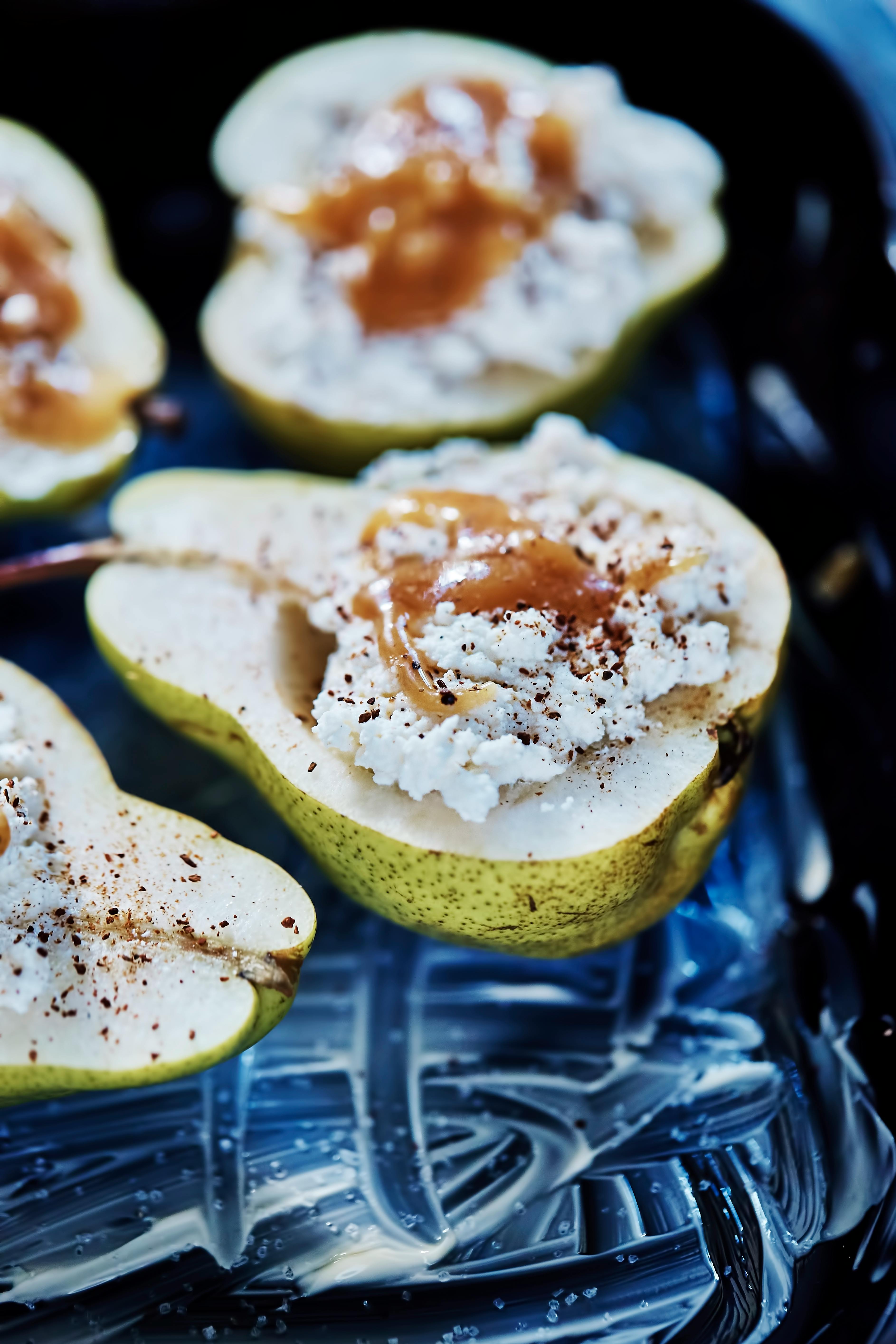 Delicious baked pears with ricotta and honey, topped with cinnamon in a rustic setting.