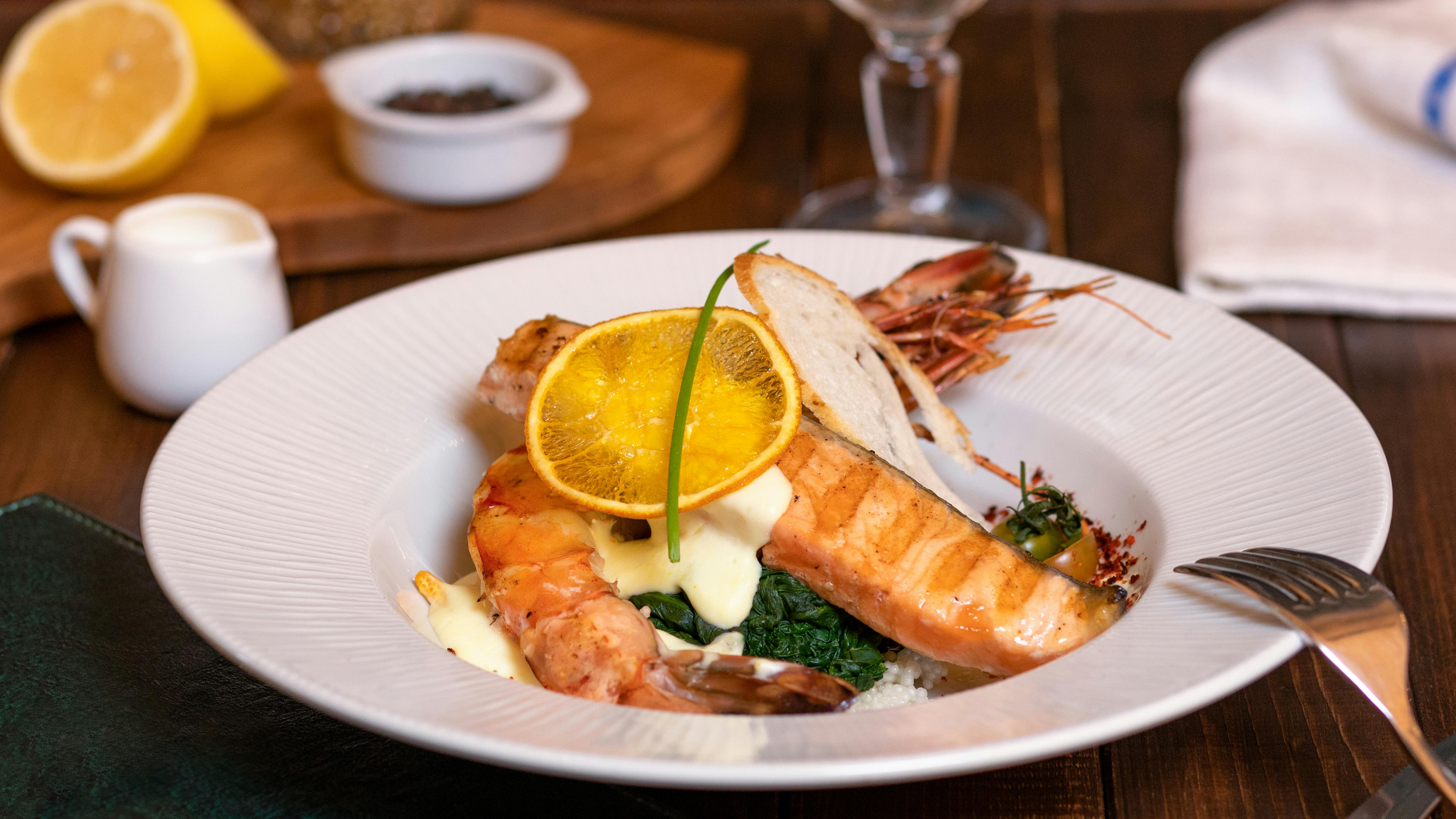 Delicious salmon and prawn dish served with lemon and herbs, perfect for gourmet dining.